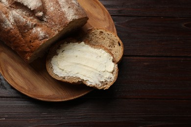 Photo of Fresh bread with butter on wooden table, top view. Space for text