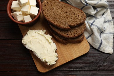 Photo of Fresh bread with butter on wooden table, top view