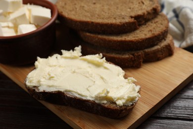 Photo of Fresh bread with butter on wooden table, closeup