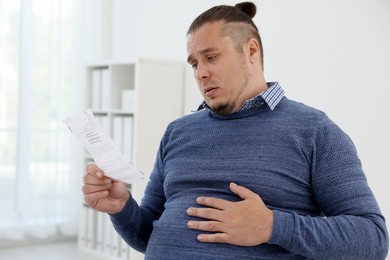 Overweight man with doctor's prescription in clinic