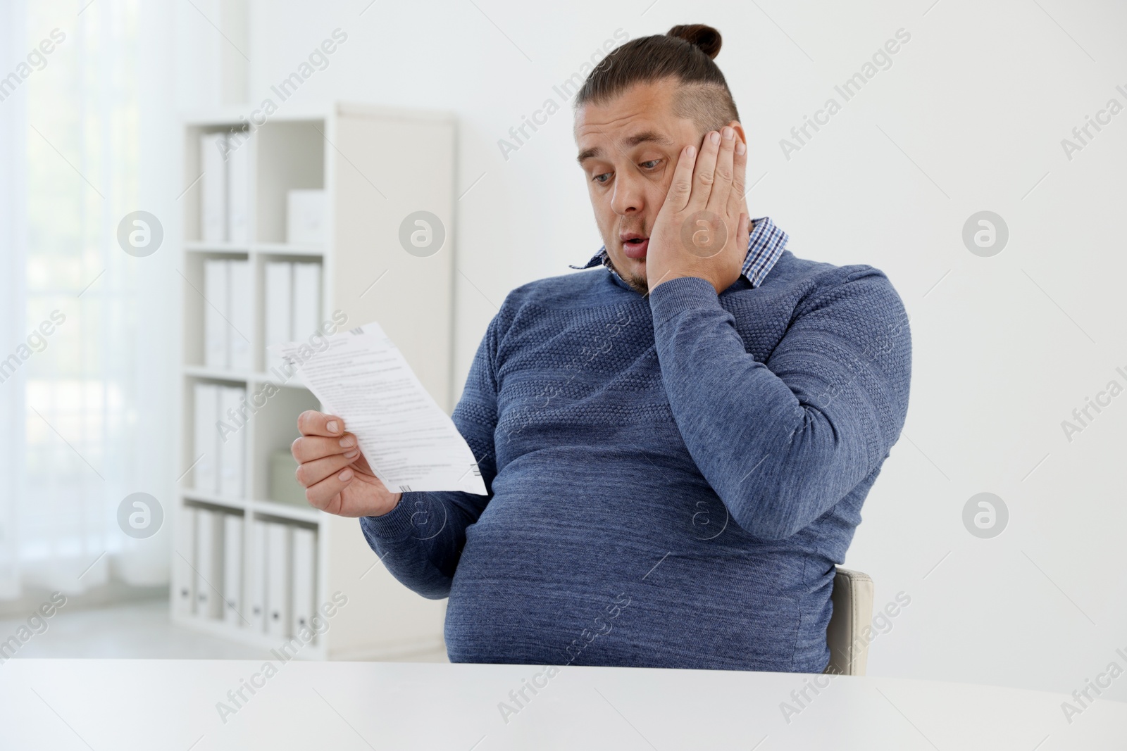 Photo of Overweight man with doctor's prescription in clinic