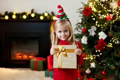 Little girl with Christmas gift at home