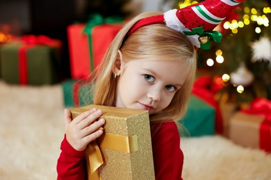 Little girl with Christmas gift at home