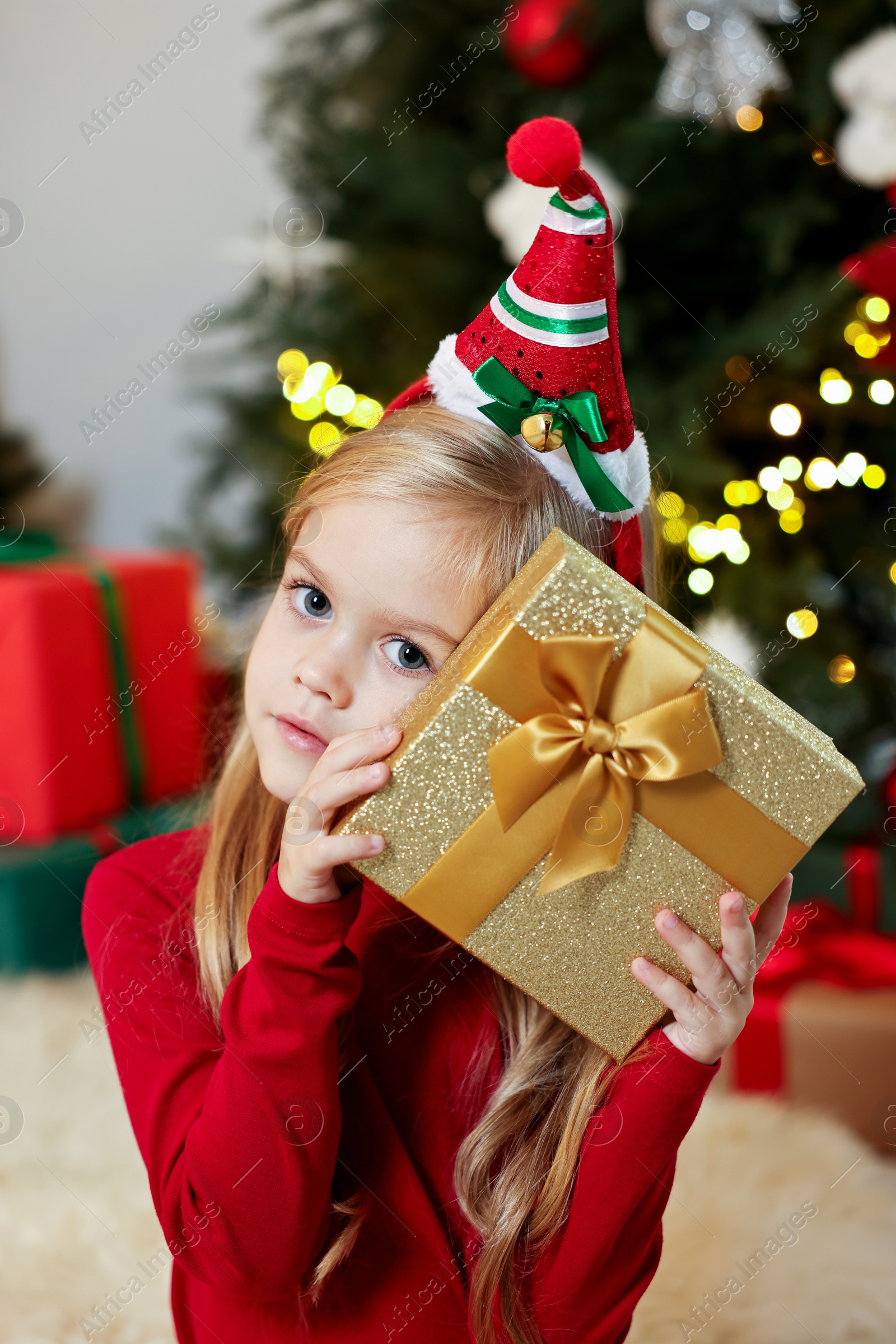 Photo of Little girl with Christmas gift at home