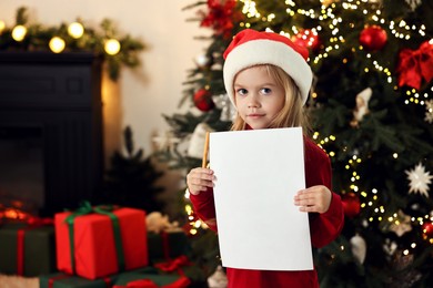 Photo of Little girl with letter for Santa Claus at home. Christmas celebration