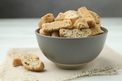 Photo of Traditional Italian almond biscuits (Cantucci) in bowl on table, closeup