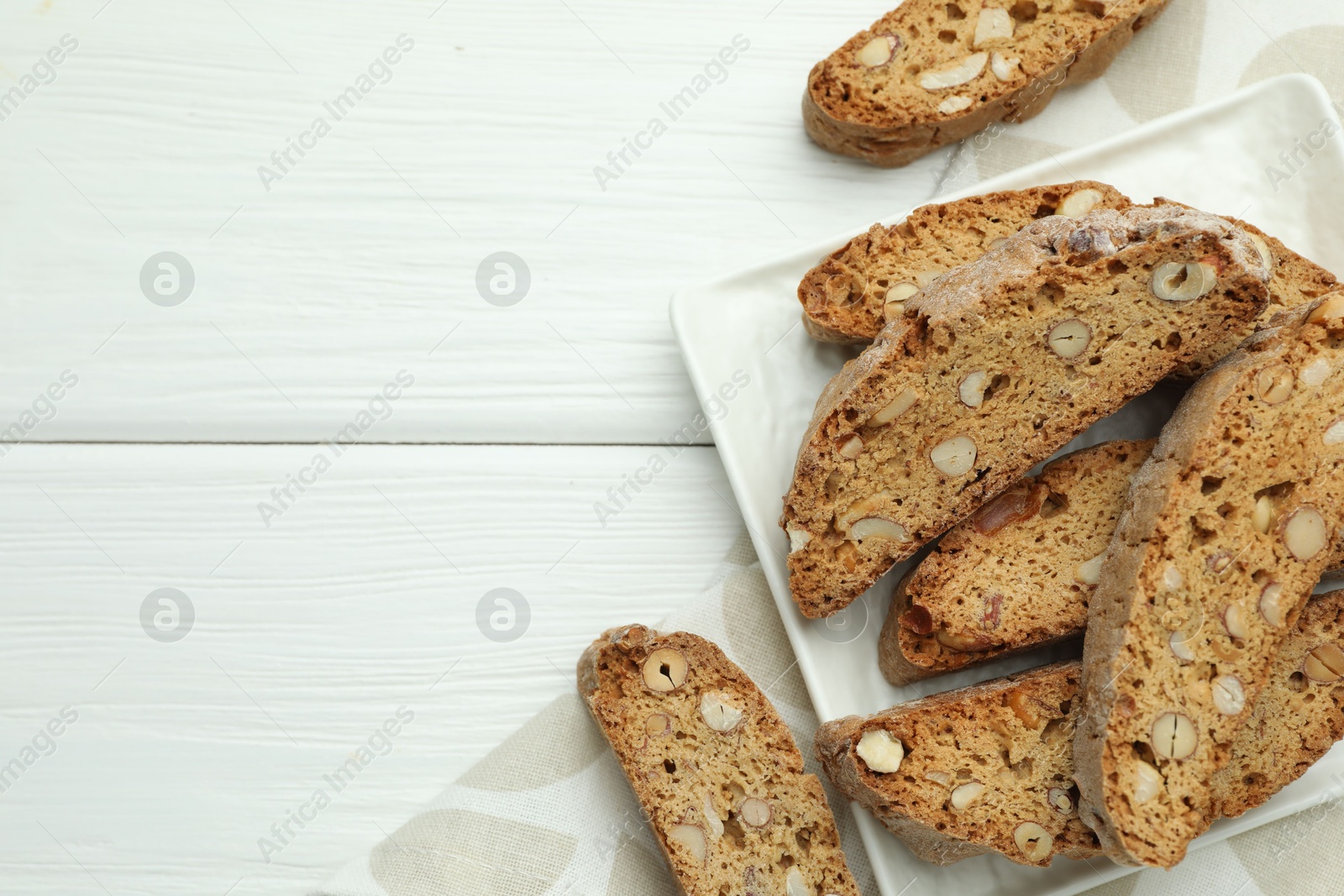 Photo of Traditional Italian almond biscuits (Cantucci) on white wooden table, top view. Space for text