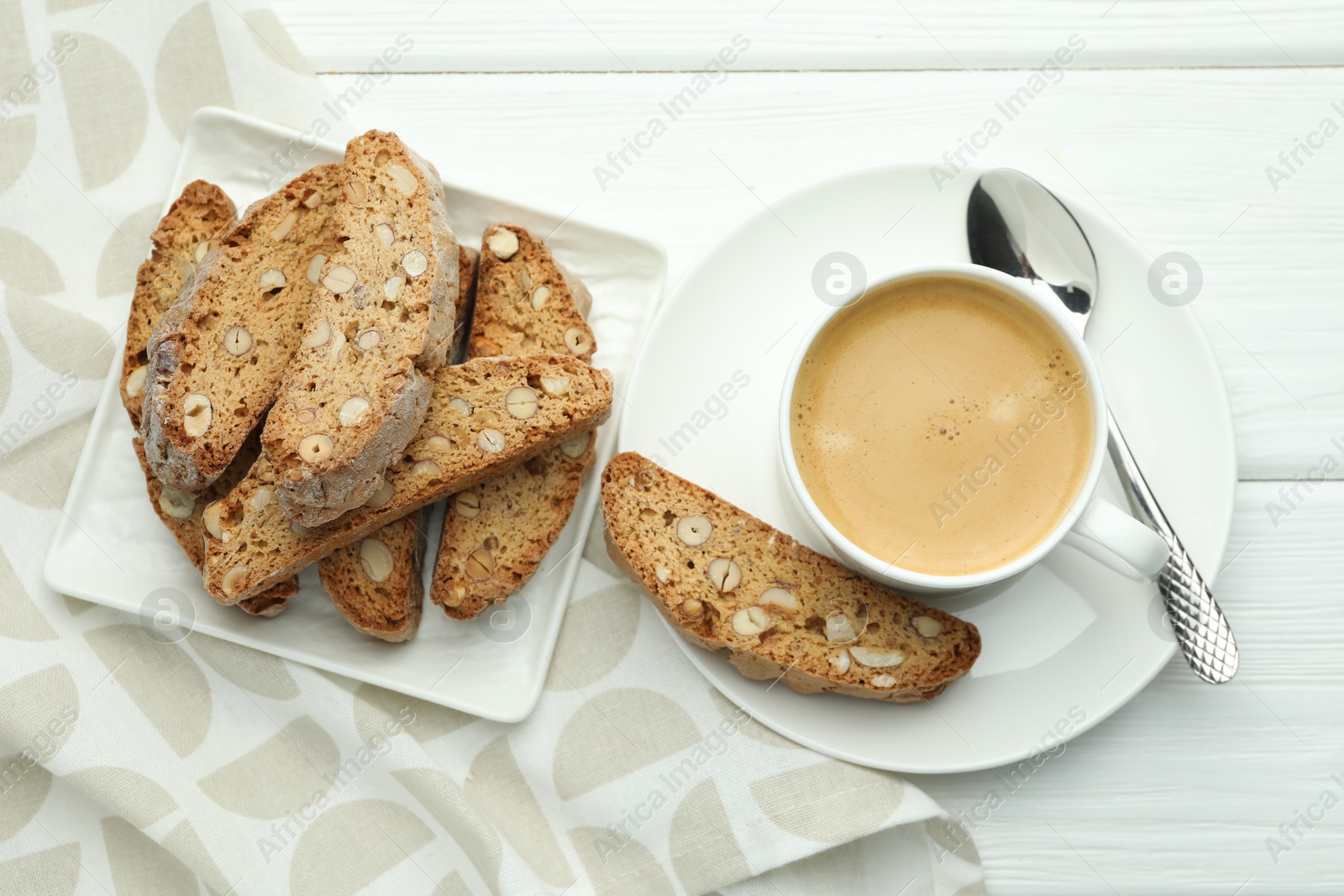 Photo of Traditional Italian almond biscuits (Cantucci) and coffee on white wooden table, top view