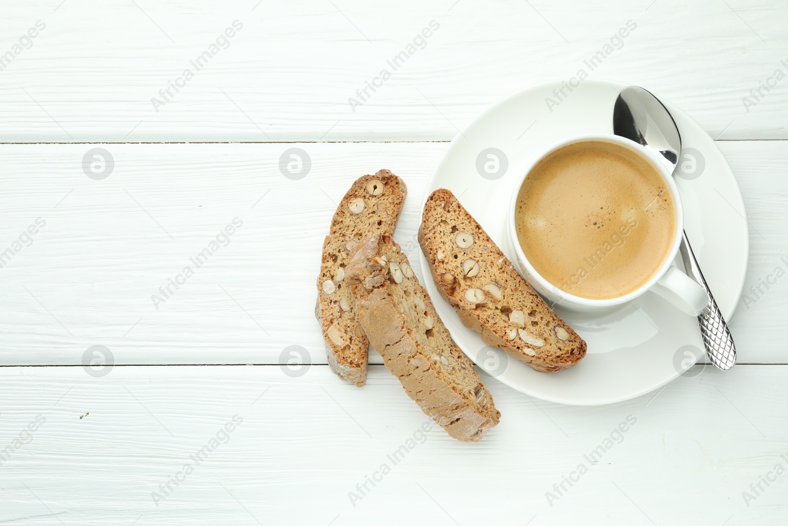 Photo of Traditional Italian almond biscuits (Cantucci) and coffee on white wooden table, top view. Space for text