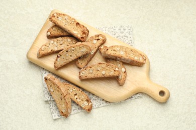 Photo of Traditional Italian almond biscuits (Cantucci) on light textured table, flat lay