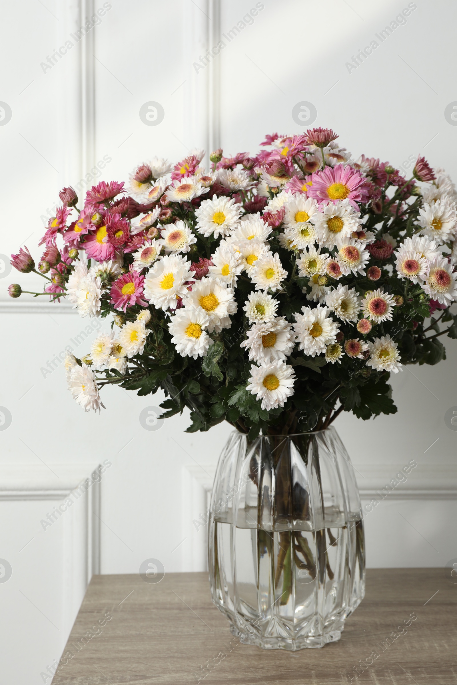 Photo of Vase with beautiful flowers on wooden table