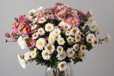 Photo of Vase with beautiful flowers on gray background, closeup