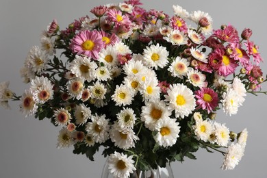 Photo of Vase with beautiful flowers on gray background, closeup