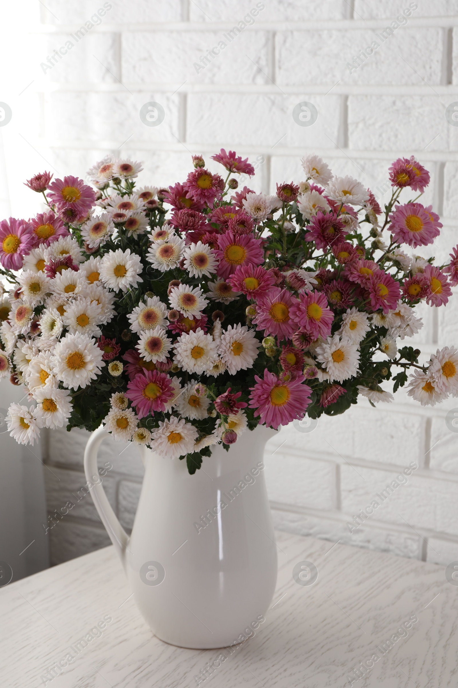 Photo of Vase with beautiful flowers on white wooden table