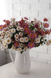 Photo of Vase with beautiful flowers on white wooden table