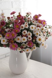 Photo of Vase with beautiful flowers on white wooden table