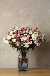 Photo of Vase with beautiful flowers on pink wooden table