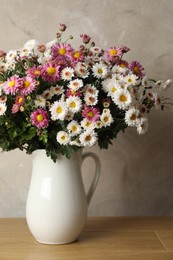 Photo of Vase with beautiful flowers on pink wooden table