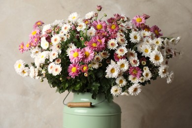 Photo of Beautiful flowers in modern vase on gray background, closeup