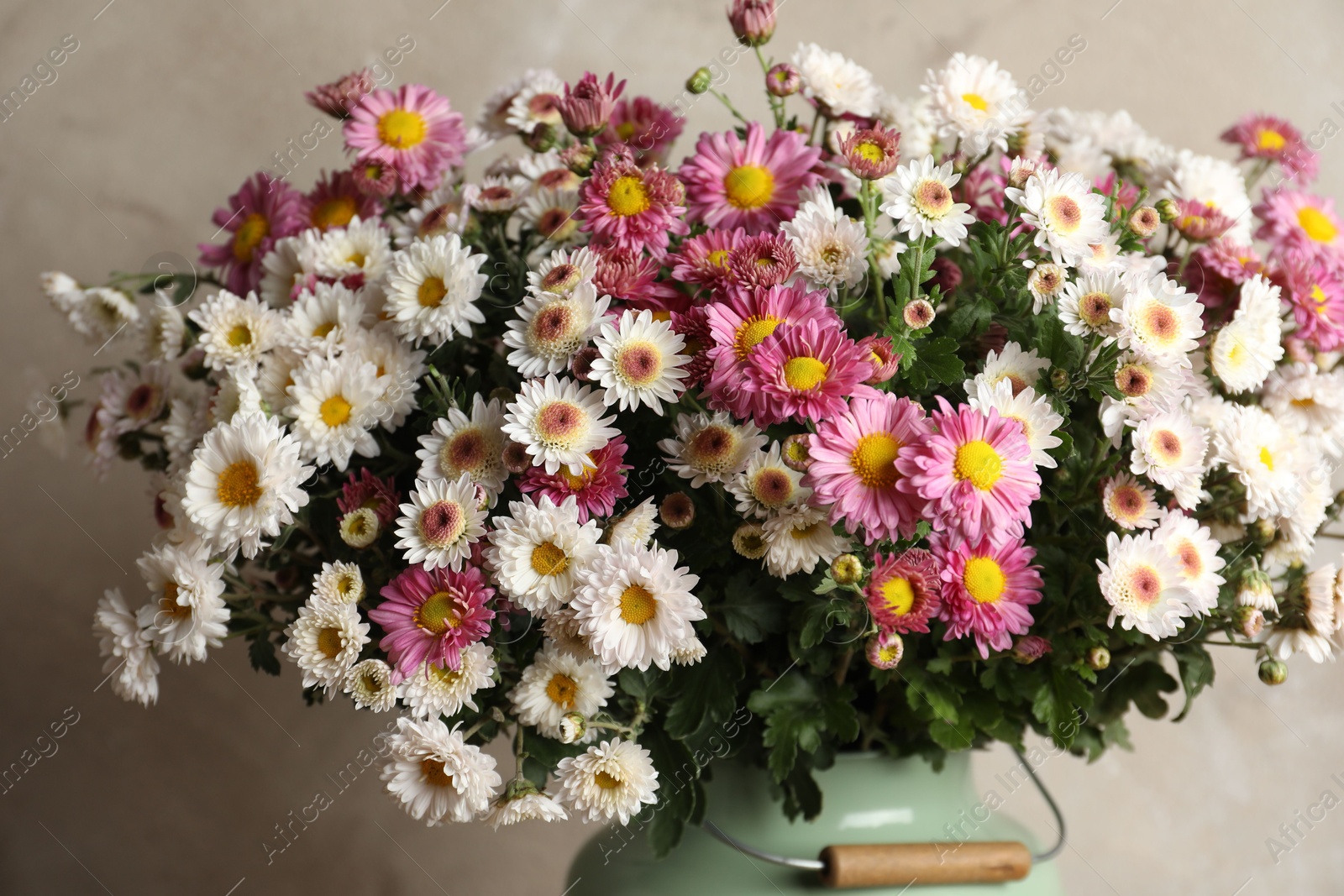 Photo of Beautiful flowers in modern vase on gray background, closeup