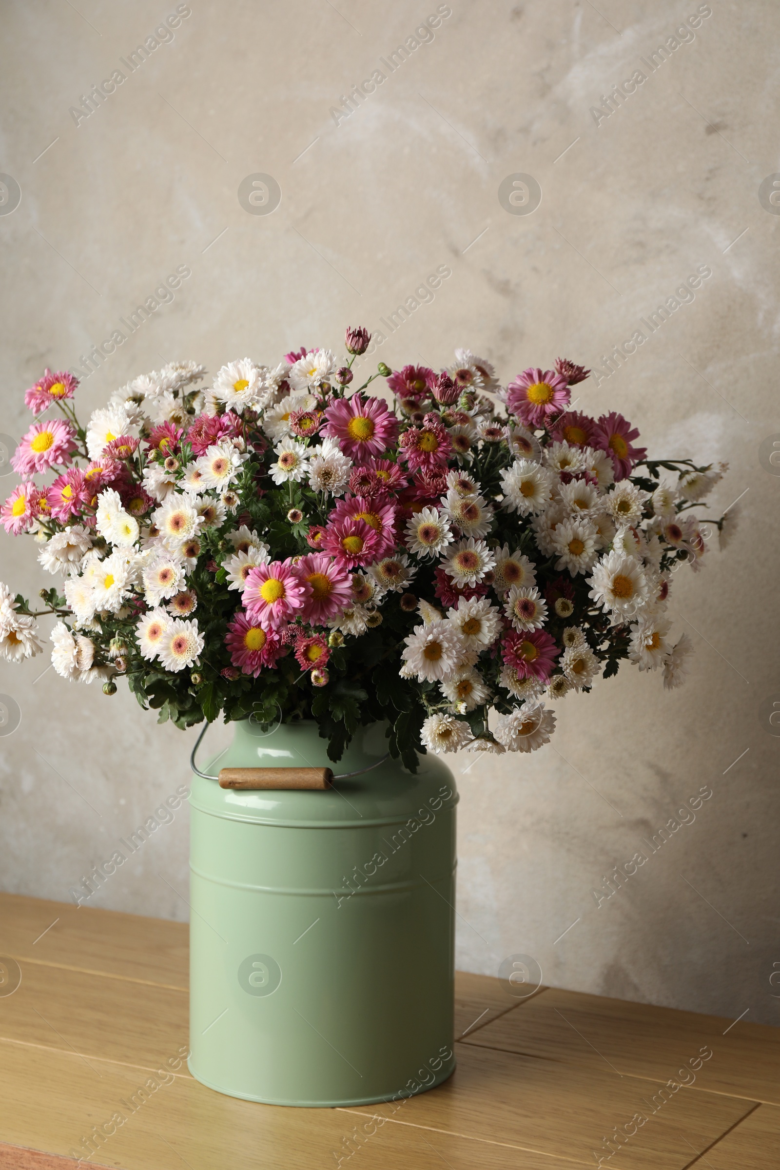 Photo of Beautiful flowers in modern vase on wooden table