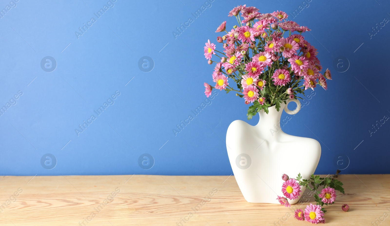 Photo of Stylish vase with beautiful flowers on wooden table. Space for text