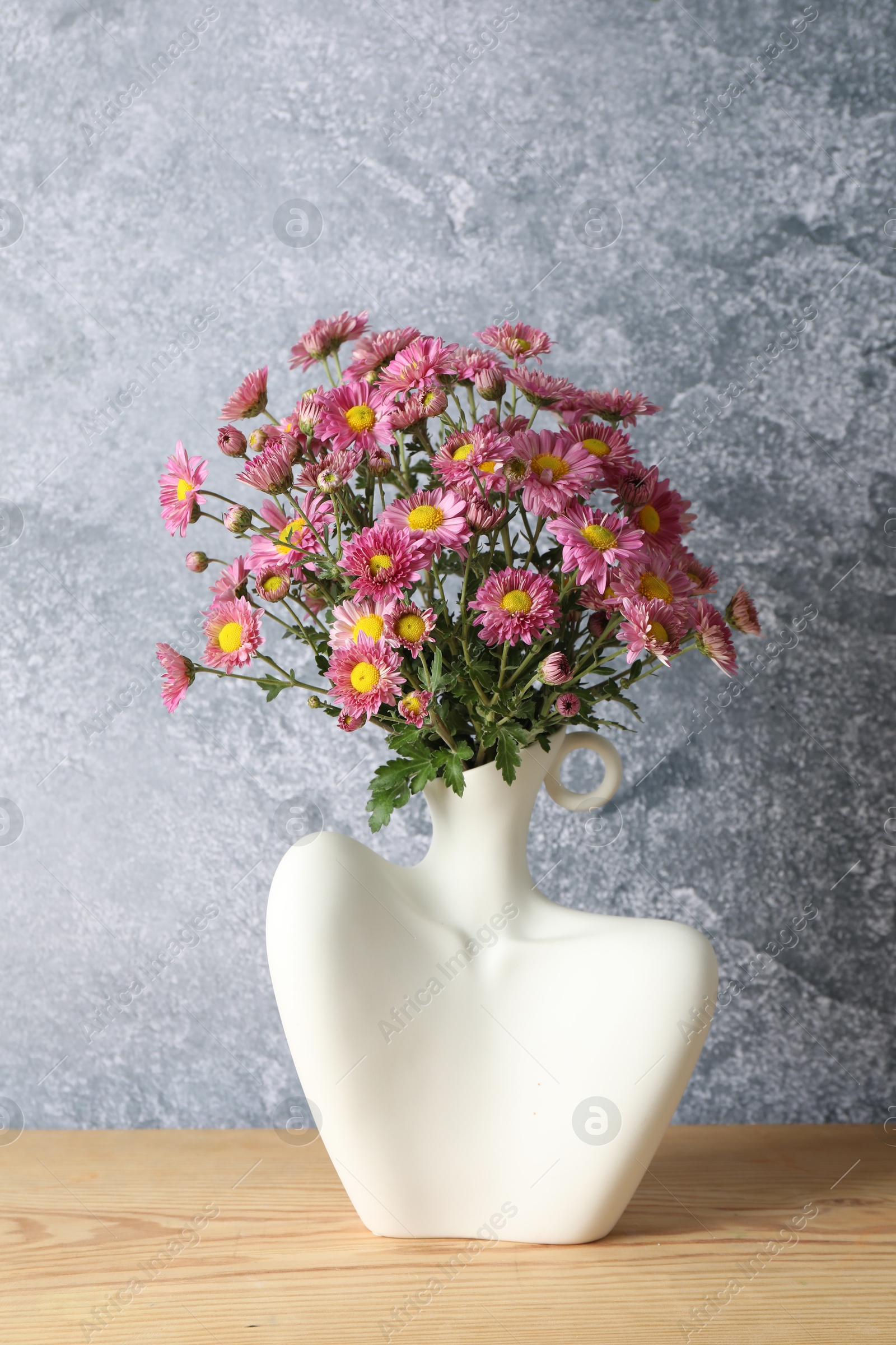 Photo of Stylish vase with beautiful flowers on wooden table