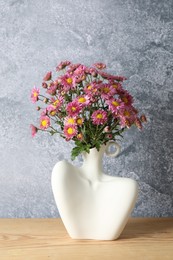 Photo of Stylish vase with beautiful flowers on wooden table