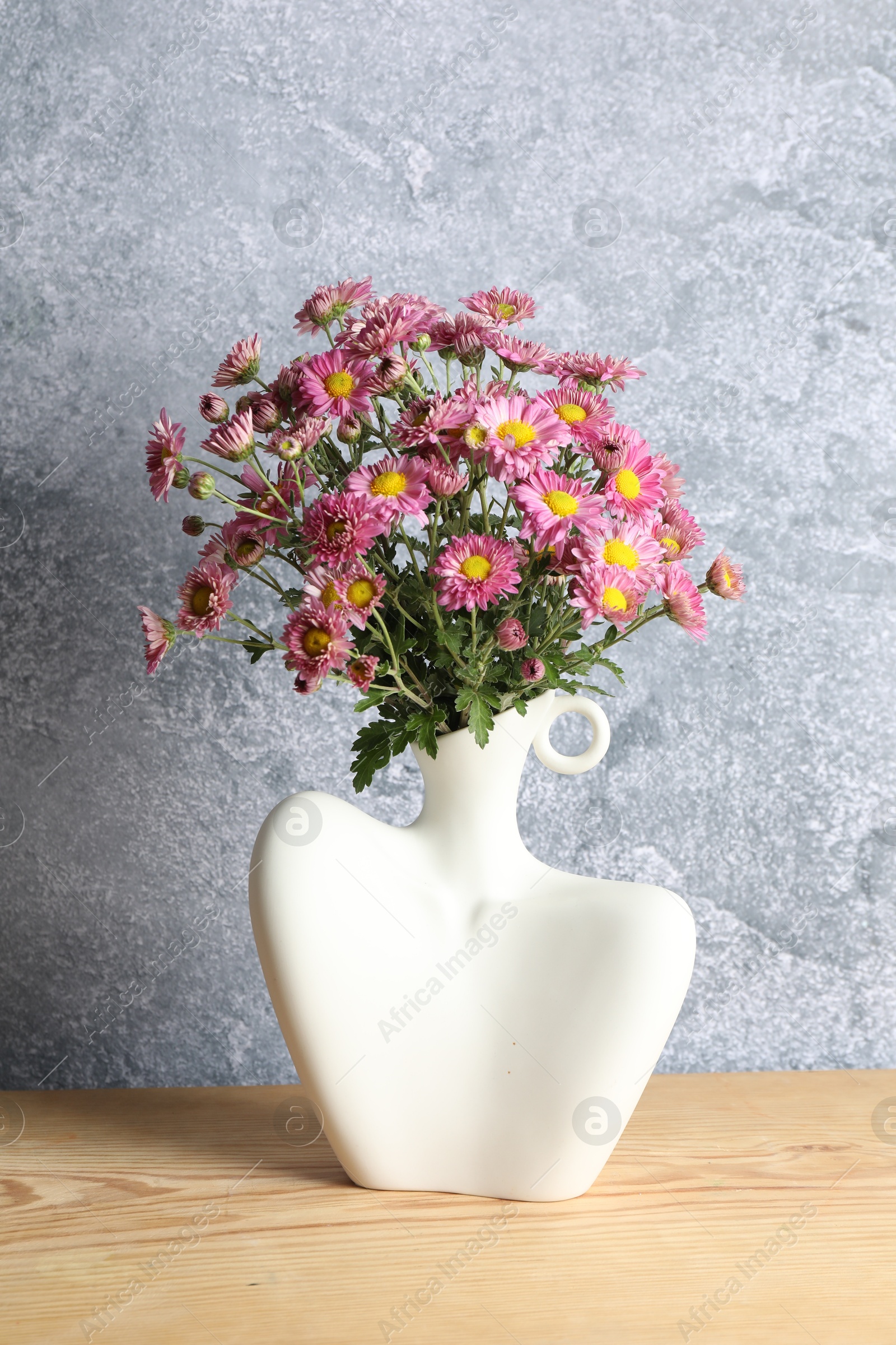 Photo of Stylish vase with beautiful flowers on wooden table