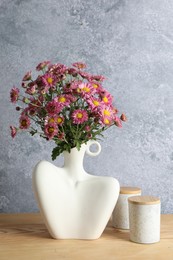 Photo of Stylish vase with beautiful flowers on wooden table