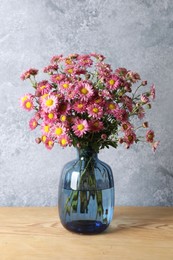 Photo of Vase with beautiful flowers on wooden table