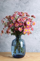 Vase with beautiful flowers on wooden table