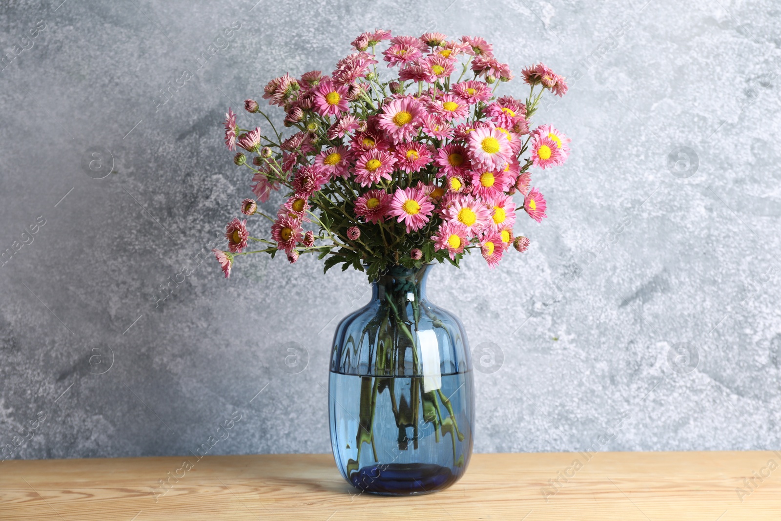 Photo of Vase with beautiful flowers on wooden table