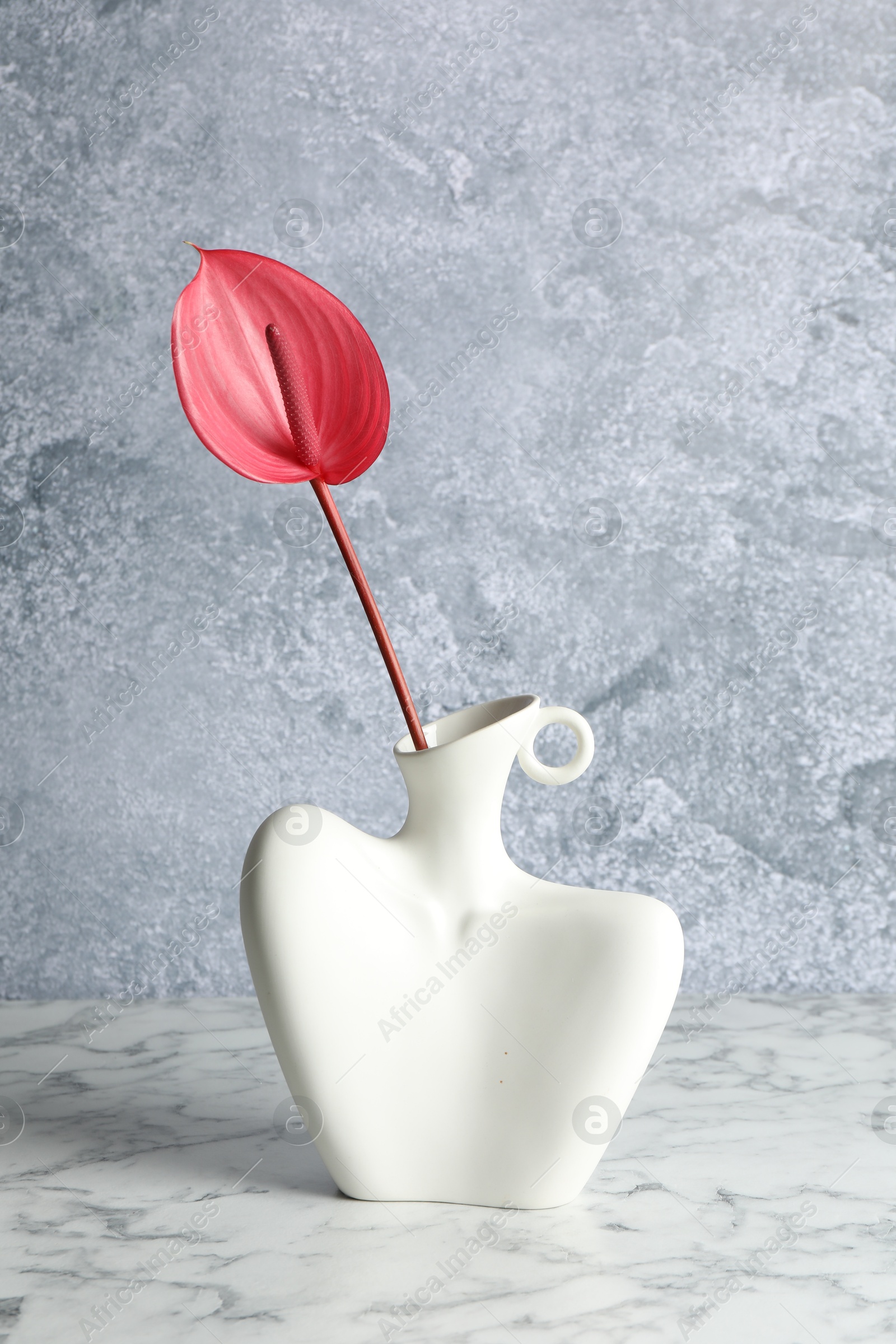 Photo of Beautiful tail flower in vase on marble table