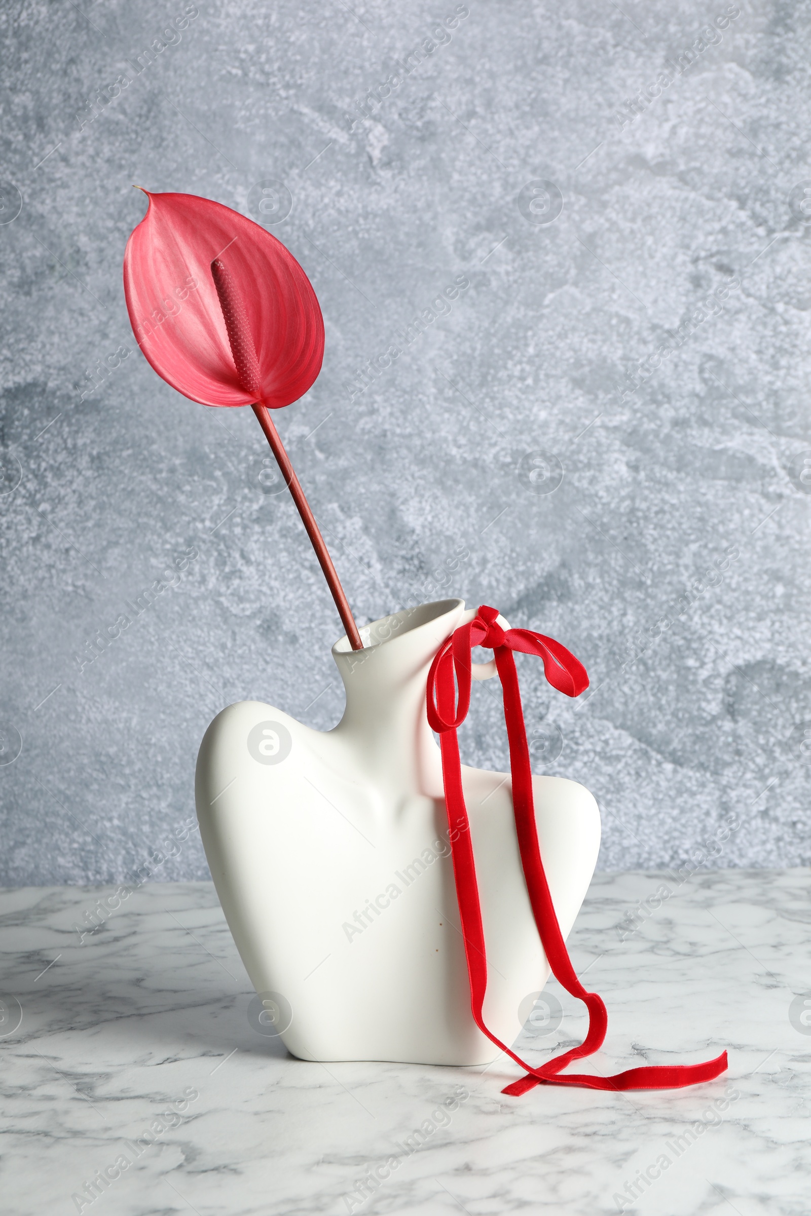 Photo of Beautiful tail flower in vase on marble table