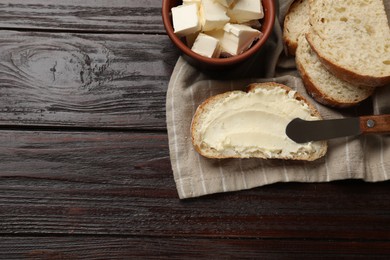 Photo of Fresh bread with butter and knife on wooden table, top view. Space for text