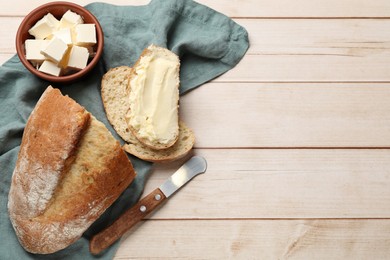 Photo of Fresh bread with butter and knife on light wooden table, flat lay. Space for text