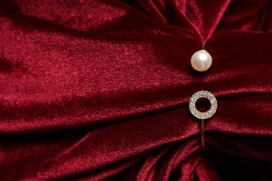 Photo of Beautiful bracelet with pearl and red cloth, top view. Space for text