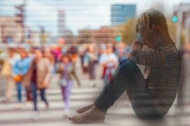 Loneliness. Sad boy sitting in room and crowded street, double exposure