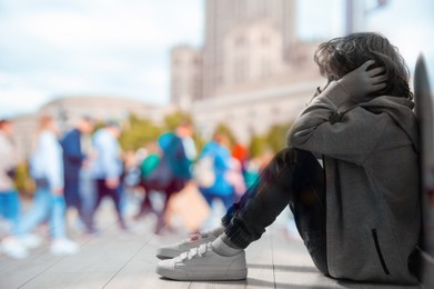 Image of Loneliness. Sad boy sitting in room and crowded street, double exposure