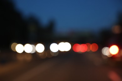 Photo of Blurred view of cityscape with road traffic and street lights in evening