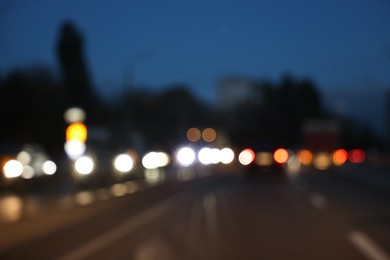 Photo of Blurred view of cityscape with road traffic and street lights in evening