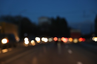 Photo of Blurred view of cityscape with road traffic and street lights in evening