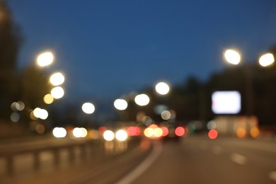 Photo of Blurred view of cityscape with road traffic and street lights in evening