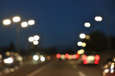 Photo of Blurred view of cityscape with road traffic and street lights in evening