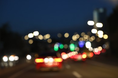 Photo of Blurred view of cityscape with road traffic and street lights in evening