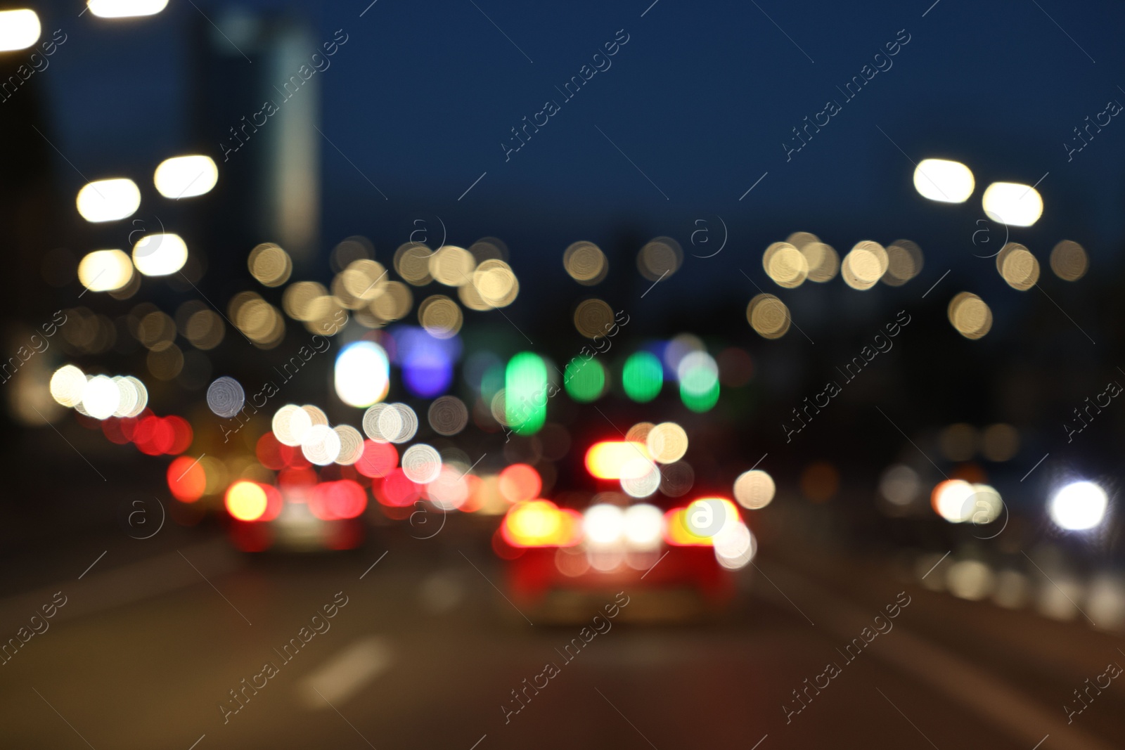 Photo of Blurred view of cityscape with road traffic and street lights in evening