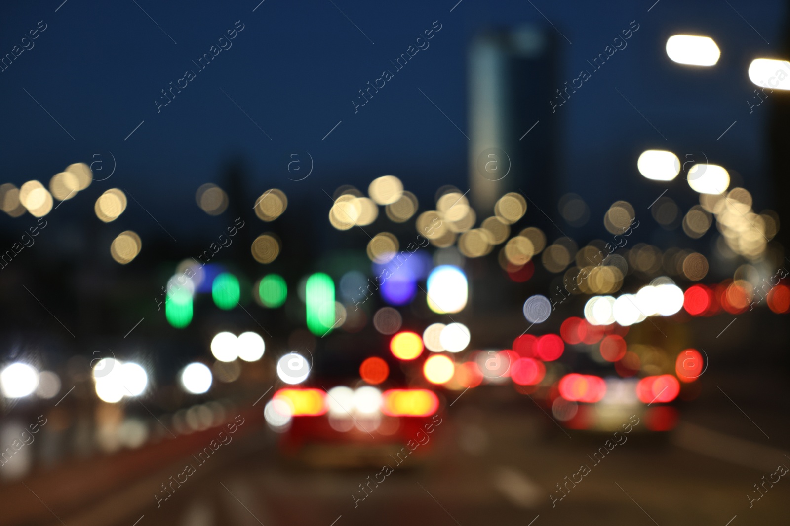 Photo of Blurred view of cityscape with road traffic and street lights in evening