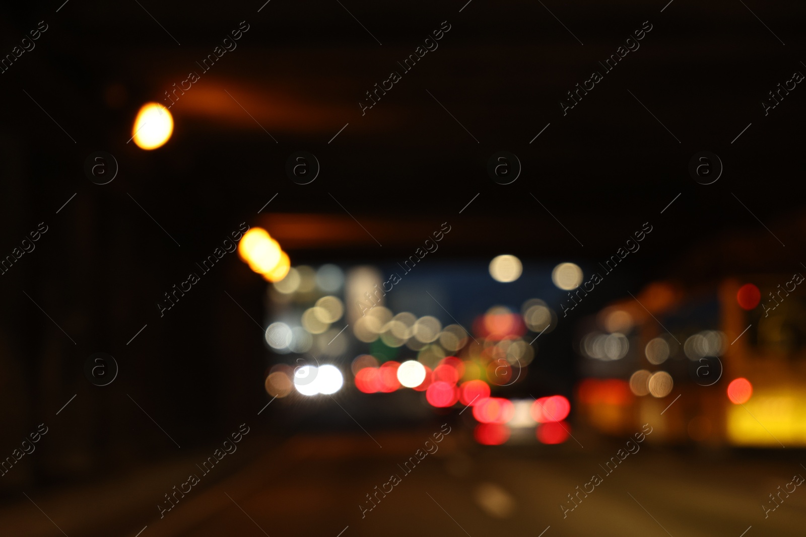 Photo of Blurred view of cityscape with road traffic and street lights at night