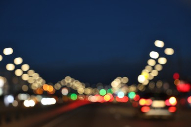 Photo of Blurred view of cityscape with road traffic and street lights in evening